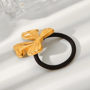 Minimalist 18K gold stainless steel bow hair tie with textured finish on white surface