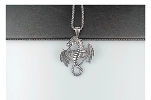Detailed close-up of a vintage silver dragon pendant with intricate metal craftsmanship