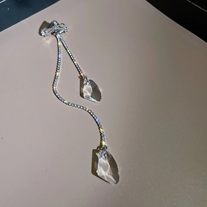 Détail de boucles d'oreilles à pampilles argentées avec pendentifs en cristal brillant