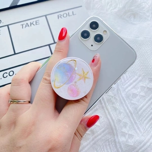 Close-up of hand holding a galaxy-themed resin phone grip with glitter and star patterns