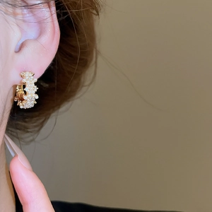 Close-up of 14K gold plated earrings with micro-set pearls and sparkling zircons