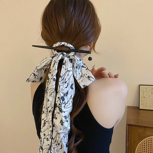 Detail of floral ribbon and black hair pin for an elegant back view hair styling