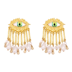 Detail of gold vintage earrings with green eye motif and white pearl tassels