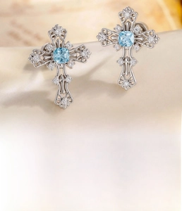 Macro shot of vintage silver cross stud earring with blue zircon stone and steel post