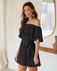 Detail of black off-the-shoulder pleated romper with matching waist tie and textured fabric