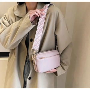 Pink minimalist crossbody bag with geometric pattern wide strap and gold hardware detail