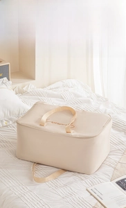 Detail of cream thickened satin quilt storage bag with brown letter embroidery and handles