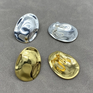 Macro view of irregular liquid metal earrings in polished gold and silver finishes