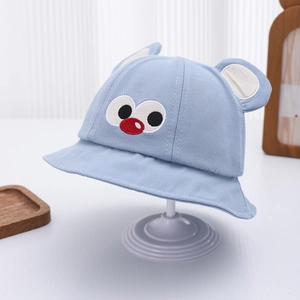 Detail of light blue baby sun hat with cute cartoon eyes and 3D ear embroidery