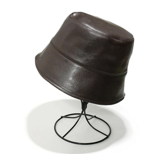 Detail of dark brown faux leather bucket hat with fine glossy texture and neat stitching