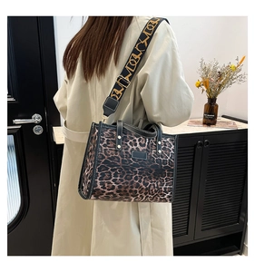 Detail of leopard print tote bag with stylish patterned strap worn with beige coat