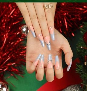 Dettaglio di unghie finte lunghe a bara con punte glitterate blu francese e piccoli strass