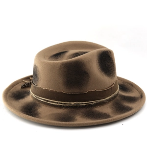 Detailed macro view of vintage brown fedora with burnt effects, fabric band and feather accent