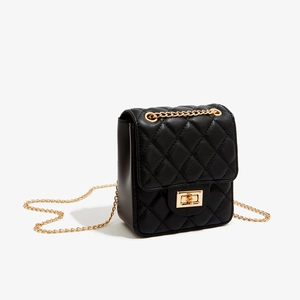 Close-up of black quilted mini bag with gold chain strap and turn-lock closure detail