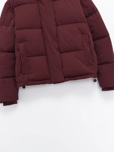Close-up of wine red quilted jacket with adjustable drawstring hem and side pocket