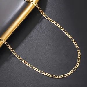 Close-up of golden Figaro chain with high-polish finish on a premium textured background