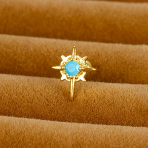 Vue macro d'un piercing d'oreille doré en forme d'étoile avec pierre turquoise