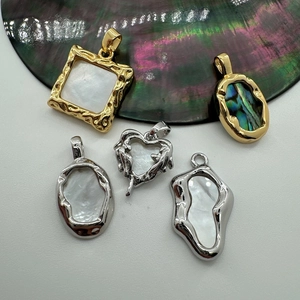 Detailed macro view of 18K gold-plated pendants with natural pearl and abalone shells