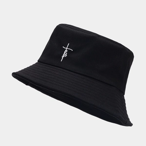 Black cotton bucket hat with white faith cross embroidery on a minimalist gray background