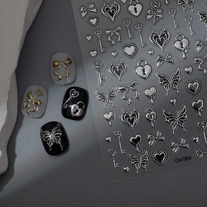 Macro shot of 3D metallic gold and silver nail stickers with butterfly and heart patterns