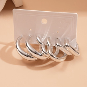 Detail of silver geometric hoop earrings set featuring round and heart shapes on display card