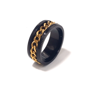 Detail view of black stainless steel spinner ring with inner golden chain for men