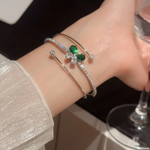 Dettaglio del bracciale farfalla in argento con zirconi a goccia verde smeraldo