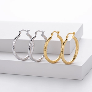 Close-up of twisted hoop earrings in gold and silver showing S925 sterling silver hallmarks