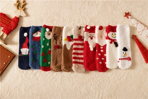 Detailed flat lay of colorful Christmas coral fleece socks with festive embroidery patterns