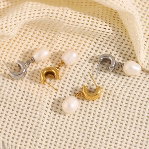 Close-up of gold and silver plated stainless steel earrings with white oval pearls