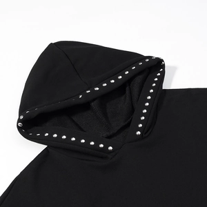 Black knitted hoodie featuring hood edges adorned with silver metal rivets on white background