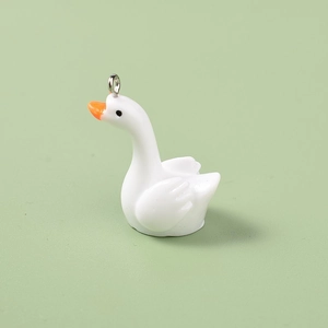 Detailed view of mini white resin swan pendant with orange beak and silver metal loop