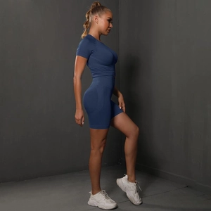 Side view of seamless blue yoga set featuring a short sleeve top and high waist shorts
