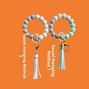 Silicone bead keychain wristlet with wooden bead and leather tassel showing two attachment styles