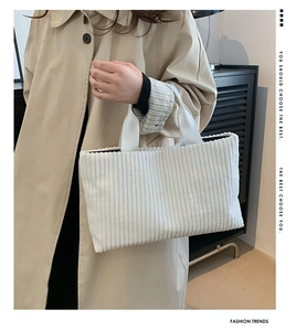 White corduroy tote bag showing thick ribbed texture and wide shoulder strap detail