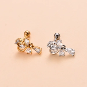 Close-up of gold and silver steel butterfly cartilage earrings with clear zircon stones