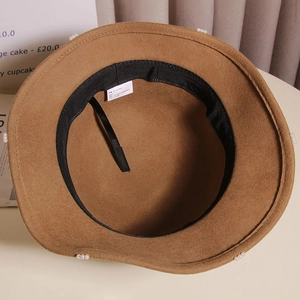 Detail view of caramel wool cloche hat showing pearl trim, inner sweatband and size label