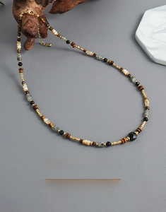 Detail view of handmade beaded necklace with tiger eye stones and golden metal clasp