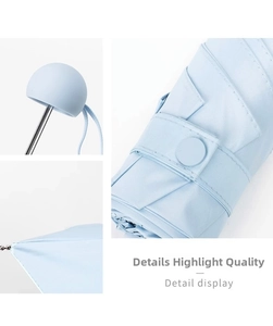 Detail view of light blue capsule umbrella showing fine twill fabric and secure button strap