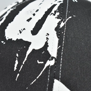 Close-up of black and white abstract print on canvas baseball cap with fine stitching
