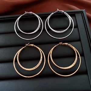 Vue détaillée de créoles doubles plaquées or 18 carats et argent avec texture torsadée