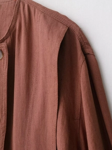Detail of red-brown faux suede jacket showing neck seam and cotton-linen texture