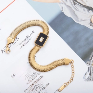 Detail of 18k gold snake chain bracelet with black stone and cubic zirconia inlay