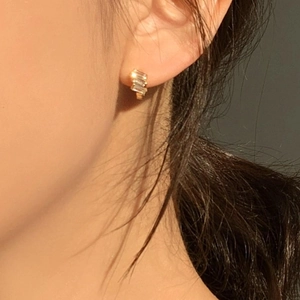 Close-up of elegant gold plated earring with rectangular clear cubic zirconia on model