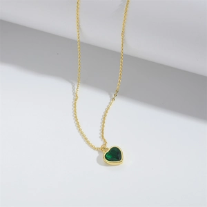 Detailed view of the heart-shaped green gemstone pendant with gold-plated bezel setting