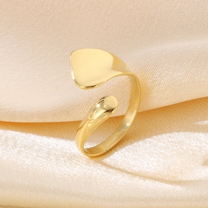 Close-up of golden 18K gold-plated irregular open ring on beige silk background