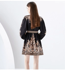 Back view of V-neck mini dress with orange-gold paisley print and lantern sleeves