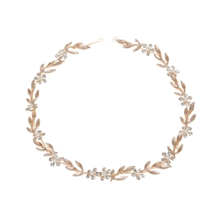 Détail d'un bandeau de mariée fait main avec feuilles dorées, perles et strass brillants