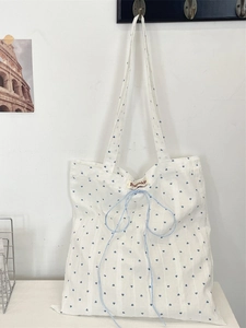 Minimalist white canvas tote bag with blue heart prints and decorative blue drawstrings