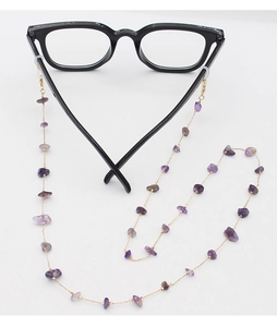 Detail of purple crystal stones and golden chain attached to black eyewear frame